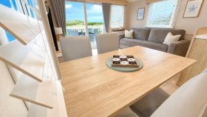 a kitchen and living room with a wooden table at Tide & Anchor - Newperran 102 in Cubert