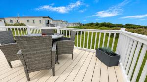 a patio with a table and chairs on a deck at Tide & Anchor - Newperran 102 in Cubert