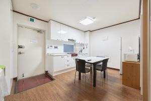a kitchen with a table and chairs in a room at Travel Home in Seoul