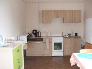 a kitchen with wooden cabinets and a white stove top oven at Kogudusemaja külalistoad in Narva-Jõesuu