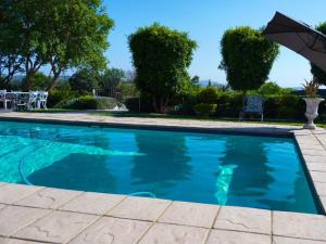 a swimming pool with an umbrella and chairs at Cradle Mount Hotel Suites in Muldersdrift