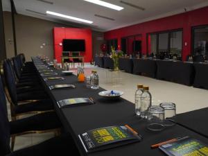 a conference room with a long table with glasses and bottles at Cradle Mount Hotel Suites in Muldersdrift +5 photos