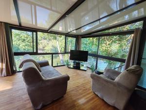 a living room with two couches and a flat screen tv at Le chalet Campy in Moustier