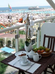 a table with a plate of fruit and a view of a beach at Hotel Thea & Residence in Gabicce Mare