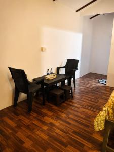 a dining room with three chairs and a table at Seashell Cottages Palolem in Canacona