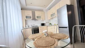 a kitchen with a glass table and a refrigerator at Затишні сучасні апартаменти в елітному ЖК Версаль in Truskavets +17 photos