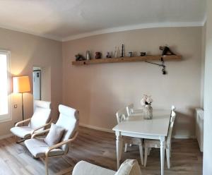 a dining room with a white table and chairs at Cal NEN PAU in Sant Boi de Lluçanès