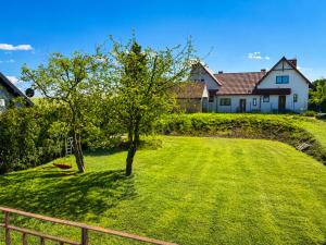 a yard with two trees and a house at Nine to Trail Apartment in Wielka Wieś