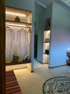 a room with a closet with white shirts and shoes at Mawamba Lodge in Tortuguero