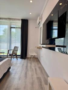 a living room with a bed and a tv at Mimar Boutique in Eforie Sud