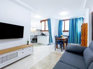 a living room with a couch and a tv at Cute Las Flores 1i with pool in Costa de Adeje