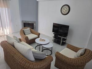 a living room with wicker chairs and a tv at Villa Nefeli in Sarandë