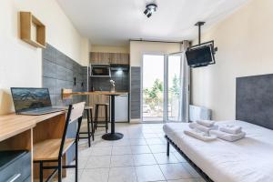 a kitchen and living room with a couch and a table at Résidence Columba - Apparts meublés Agen Sud in Agen