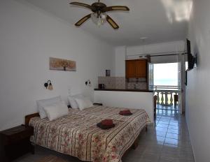 a bedroom with a bed and a ceiling fan at Seasound in Agios Stefanos