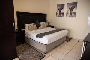 a bedroom with a large bed and two pictures on the wall at Ecotel Southgate in Southgate +14 photos