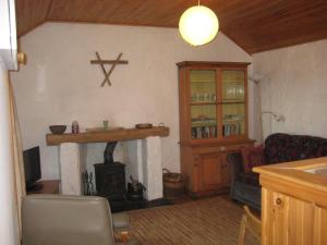 een woonkamer met een open haard, een bank en een tafel bij Fishers Croft in Hamnavoe