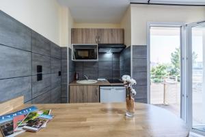 a kitchen with a wooden table in a room at Résidence Columba - Apparts meublés Agen Sud in Agen