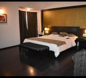 a large bedroom with a large bed and a chair at hotel royal highness in Ahmedabad