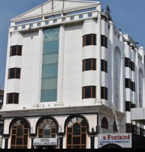 a tall white building with a lot of windows at hotel royal highness in Ahmedabad