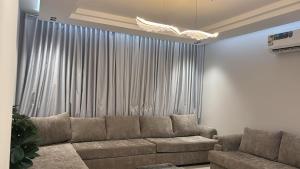 a living room with a couch in front of a window at شقه دار المشاعر فى دار الاركان لشقق لاكجرى in Mecca +5 photos