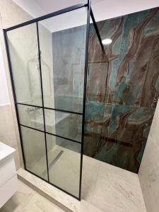 a glass shower in a bathroom with a painting on the wall at Mimar Boutique in Eforie Sud +78 photos