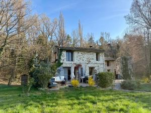 an old stone house in the middle of a yard at La Source in Rustrel