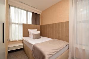 a small bedroom with a bed and a window at Nord Gate Avenue Hotel in Yerevan +77 photos