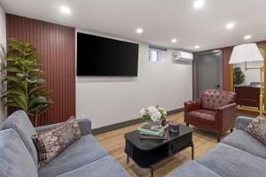 a living room with a couch and a chair and a tv at Harvard Charm Near Boston New build in Cambridge