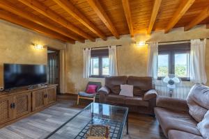 a living room with a couch and a flat screen tv at Paraje Navazos in Gavilanes