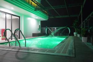 a swimming pool with a water fountain in a building at Khách sạn Hercury FLC Sầm Sơn in Sầm Sơn