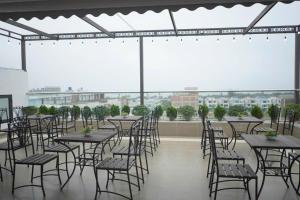 a group of tables and chairs on a roof at Khách sạn Hercury FLC Sầm Sơn in Sầm Sơn