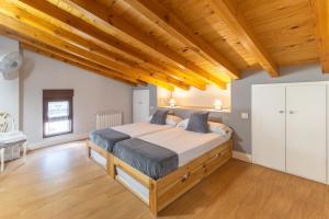 a bedroom with a large bed and wooden ceilings at Paraje Navazos in Gavilanes +24 photos