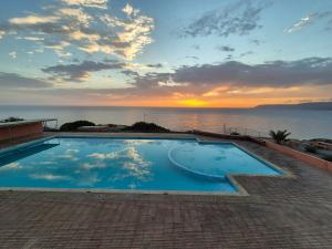 a swimming pool with a view of the ocean at sunset at Terre d'Océan in Taghazout