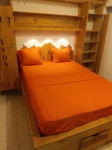 an orange bed in a room with a ladder at Hôtel chez Dan in Antsiranana