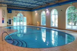 a large swimming pool in a building with windows at Best Western The Royal Chase Hotel in Shaftesbury