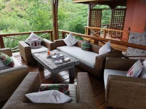 a screened in porch with couches and a table at Villa Vanilla in Port Glaud