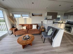 a living room with a couch and a table at Camping Zeezicht - Chalet 16 in Westerland +10 photos