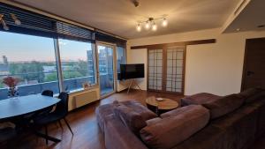 a living room with a couch and a table at Modern skyline-view condo at a luxury complex in Vilnius +9 photos