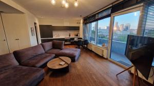 a living room with a couch and a flat screen tv at Modern skyline-view condo at a luxury complex in Vilnius