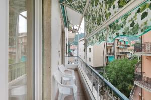 a balcony of a building with white chairs at Casa Antonio in Alassio