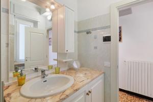 a white bathroom with a sink and a mirror at Casa Antonio in Alassio +15 photos