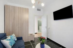 a living room with a blue couch and a tv at Casa Antonio in Alassio