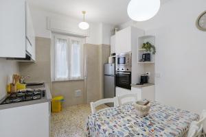a small kitchen with a table and a stove and refrigerator at Casa Antonio in Alassio
