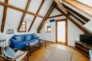 a living room with a blue couch and a tv at Casa.Peiso in Mörbisch am See