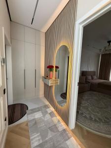 a hallway with a mirror and a living room at Жк Prime Park 2 in Shymkent +5 photos