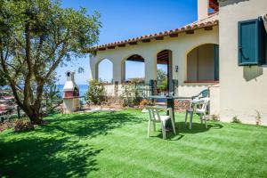 a yard with chairs and a table in the grass at Il Fortino Sea View in Geremèas