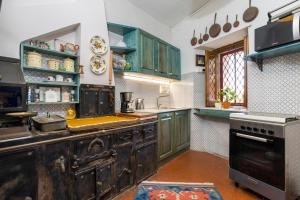 an old fashioned kitchen with green cabinets and a stove at Casa Edera - Villa Storica in Viagrande +23 photos