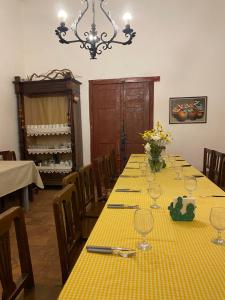 a dining room with a table with a yellow table cloth at Hosteria El Capricho in Seclantás