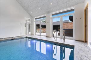 an empty swimming pool in a house with windows at Feriehus 1116 in Ringkøbing