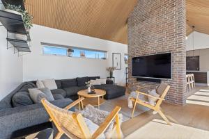 a living room with a couch and a brick fireplace at Feriehus 1116 in Ringkøbing